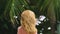 Beautiful blond woman touches her hair in nature and looks at the camera smiling. hair treatment concept