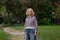 Beautiful blond women wearing casual striped hoodie and jeans walking in the park