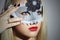 Beautiful Blond Young Woman in Carnival Mask.Masquerade. Beauty Girl with red lips. Manicure