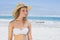 Beautiful blonde on the beach in white bikini and sunhat