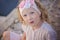 Beautiful blonde blue eyed child girl portrait in pink and white headband