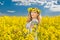 Beautiful blonde with blue eyes smiling in rapeseed field