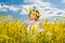 Beautiful blonde with blue eyes smiling in rapeseed field