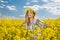 Beautiful blonde with blue eyes smiling in rapeseed field