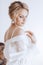 Beautiful blonde bride with stylish make-up in white dress.Morning bride