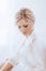 Beautiful blonde bride with stylish make-up in white dress.Morning bride