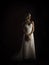 Beautiful blonde bride wearing vintage strapless wedding gown standing in the rain