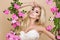 Beautiful blonde bride in a wedding dress on a swing decorated with roses
