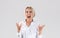 Beautiful blonde businesswoman in office wear shouting in anger on light studio background