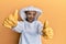 Beautiful blonde caucasian woman wearing protective beekeeper uniform approving doing positive gesture with hand, thumbs up
