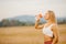 Beautiful blonde drinks water after workout in park from sports bottle