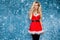 Beautiful blonde female model dressed in a Santa Claus hat and dress. Sensual girl for Christmas.