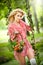 Beautiful blonde with flowers basket in leafy swing