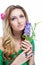 Beautiful blonde girl with bright makeup, long curled hair and massive jewelry holding a blossoming branch on white backg