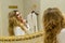 Beautiful blonde girl corrects her hair and looking in the mirror in her bathroom. Beauty young woman corrects her hair