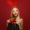 Beautiful blonde girl in a New Year`s image with Christmas bells around her neck and deer horns on her head. Beauty face