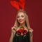 Beautiful blonde girl in a New Year`s image with Christmas bells around her neck and deer horns on her head. Beauty face
