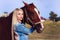 Beautiful blonde girl taking care of the horse at the ranch