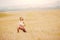 Beautiful blonde girl in white T-shirt is stretching in park field, yoga concept