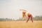 Beautiful blonde girl in white T-shirt is stretching in park field, yoga concept