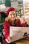 Beautiful blonde-haired businesswoman reading news sitting in cafeteria