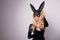 Beautiful blonde-haired young woman in carnival mask ballroom rabbit with long ears sensual in a black dress