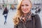 Beautiful blonde happy woman walking on the street in city. Outdoor photo.