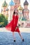 Beautiful blonde lady in red dress on Red Square