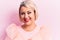 Beautiful blonde plus size woman wearing pincess tiara with diamonds over pink background with a happy and cool smile on face