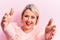 Beautiful blonde plus size woman wearing pincess tiara with diamonds over pink background looking at the camera smiling with open