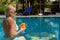 Beautiful blonde relaxes sunbathes near the pool on vacation
