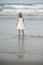 Beautiful blonde teenage girl wading in sea