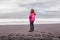 Beautiful blonde tourist on the black beach of Vik