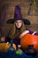 Beautiful blonde witch in purple Halloween with a broom