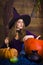 Beautiful blonde witch in purple Halloween with a broom