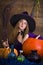 Beautiful blonde witch in purple Halloween with a broom