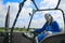 Beautiful blonde woman farmer riding a red tractor to till the soil in order to be able to work in the vegetable garden