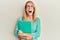 Beautiful blonde woman holding book wearing glasses angry and mad screaming frustrated and furious, shouting with anger looking up