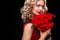 Beautiful blonde woman holding bouquet of red roses. Saint Valentine and International Women`s Day, Eight March