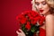 Beautiful blonde woman holding bouquet of red roses. Saint Valentine and International Women`s Day, Eight March
