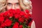 Beautiful blonde woman holding bouquet of red roses. Saint Valentine and International Women`s Day, Eight March