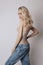 Beautiful blonde woman with long hair in jeans. Skinny girl with long legs, weight loss, perfect figure