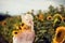 Beautiful blonde woman with long hair and sunhat in a rural sunflowers field outdoors