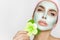 Beautiful blonde woman model with a green facial mask, beauty spa