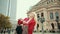 Beautiful blonde woman in red jacket picks up heavy large bag