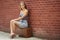 Beautiful blonde woman in strapless sundress with vintage suitcase