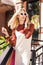 beautiful blonde woman in sunglasss holding shopping bags and talking by smartphone