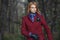 Beautiful blonde woman in tweed jacket and leather gloves in autumn forest