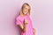 Beautiful blonde woman wearing casual pink tshirt beckoning come here gesture with hand inviting welcoming happy and smiling