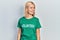 Beautiful blonde woman wearing volunteer t shirt looking away to side with smile on face, natural expression